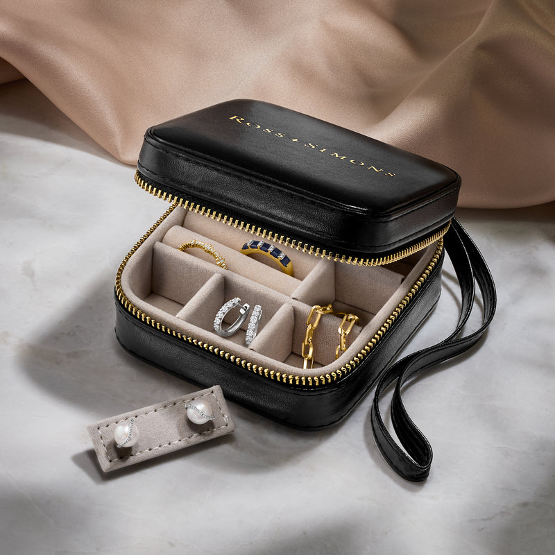 Black faux leather jewelry travel case open with ring compartments and small snap organizer