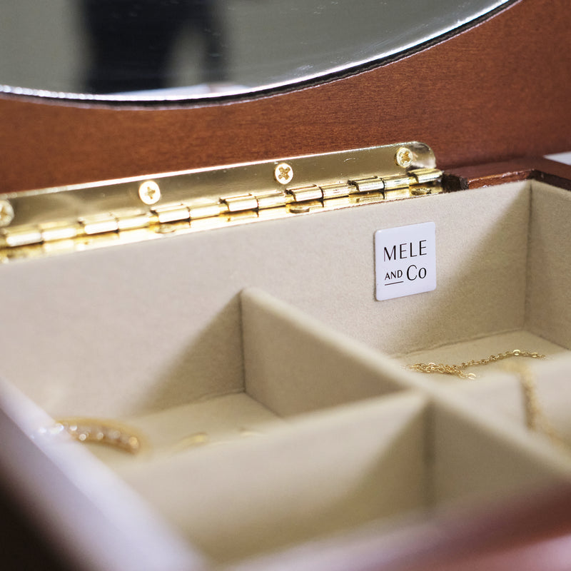 Mele & Co. jewelry box interior with cream compartments and gold-tone hinge hardware
