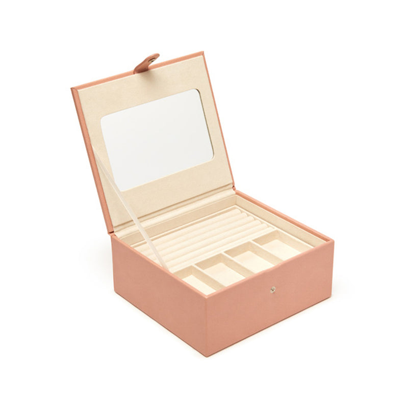 Blush faux leather three-tray jewelry box with hinged lid and open storage compartments
