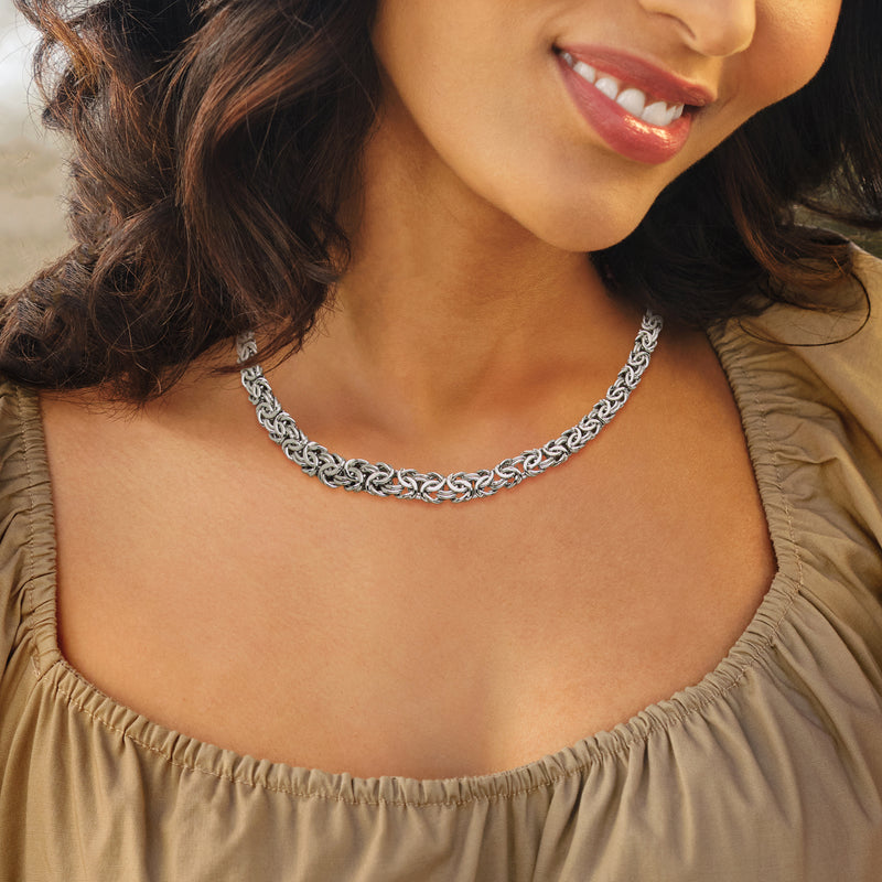 Sterling silver chain necklace with graduated Byzantine links, worn close to neckline