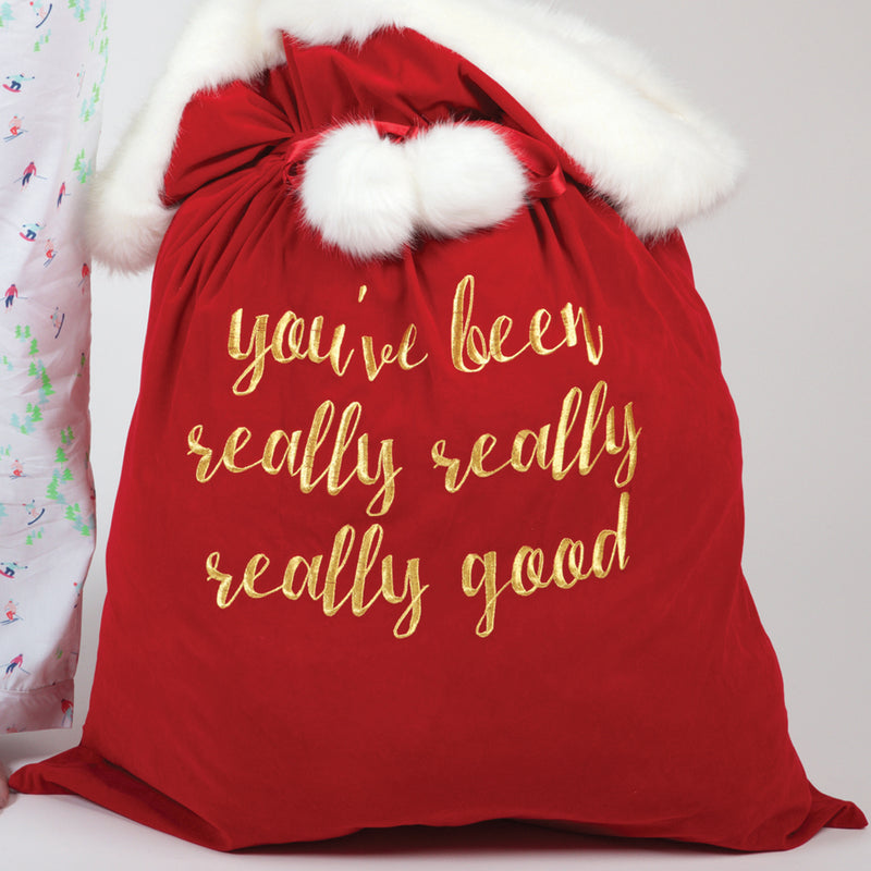 Red velvet Santa bag with white faux fur trim and gold script message