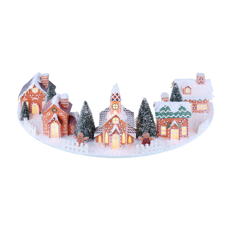 Gingerbread-style Christmas village with small houses and pine trees on a snowy base
