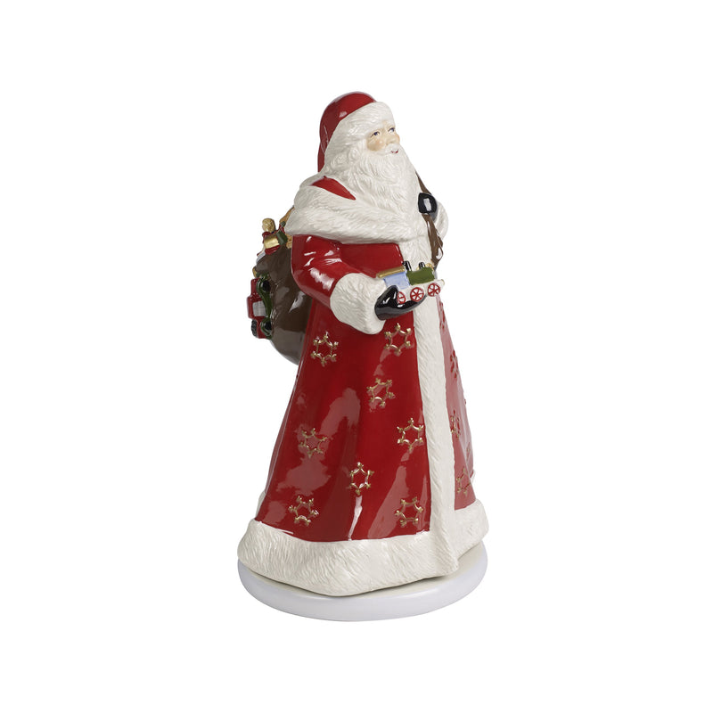 Santa Claus figurine in red coat with white beard, holding a music box device