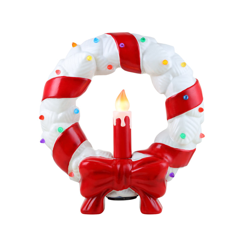 White blow-mold Christmas wreath with red bows and lit candle centerpiece