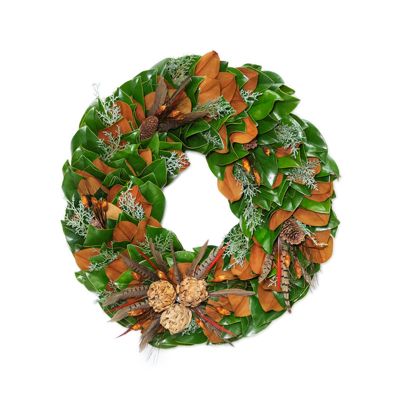Green and brown leaf wreath with orange feather accents and pine sprig clusters