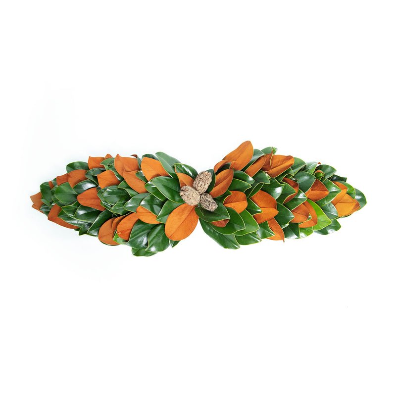 Fresh magnolia centerpiece bow with orange flowers and green leaves