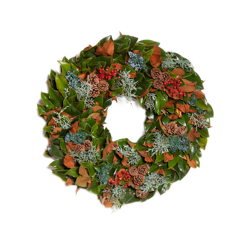 Fresh green wreath with orange leaves, red berries, pine sprigs, and small pinecones