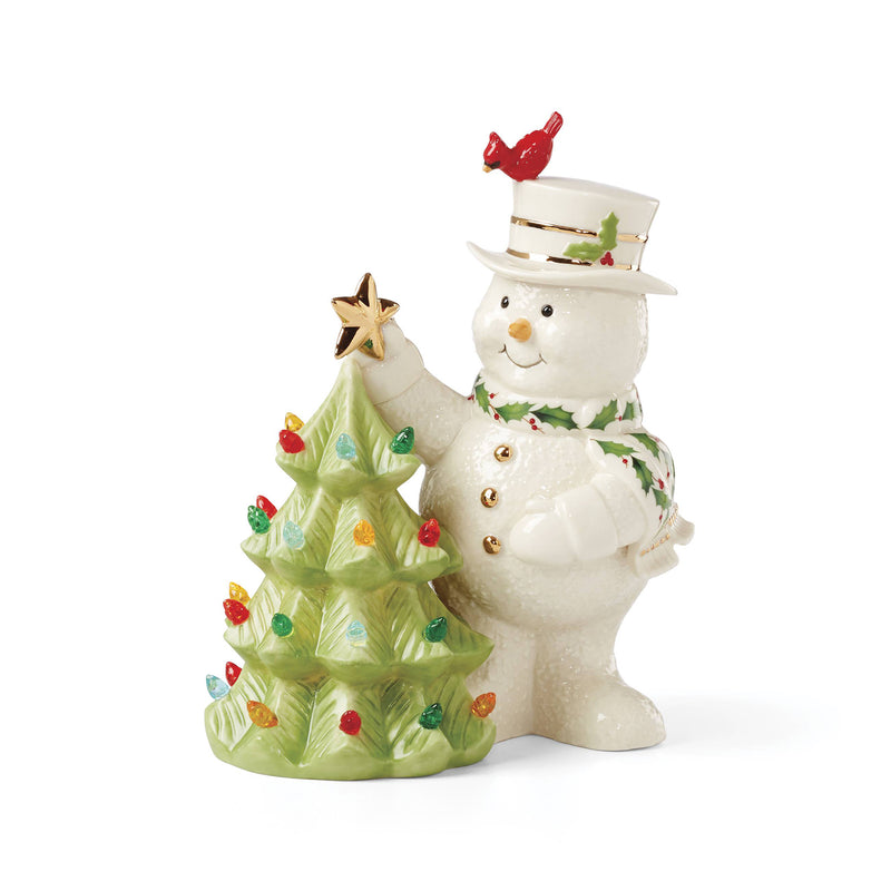 Lenox porcelain snowman figurine with top hat, holding a star, beside a decorated tree