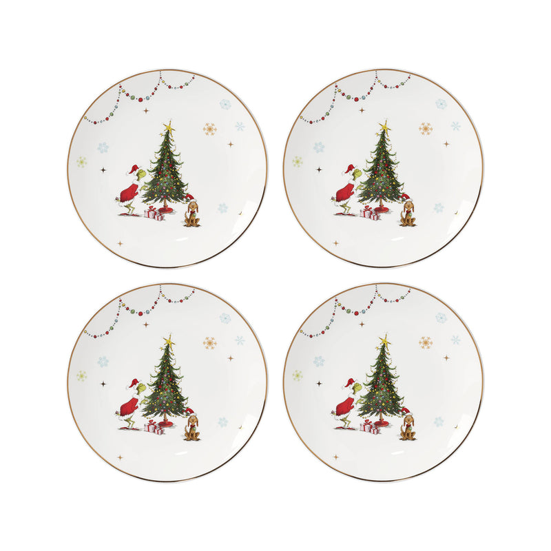 Set of four porcelain dinner plates with Christmas tree scene and gold rim.