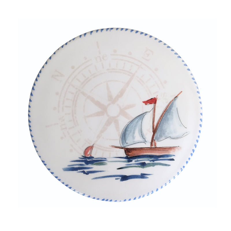 Round ceramic trivet with blue sailboat illustration and scalloped edge