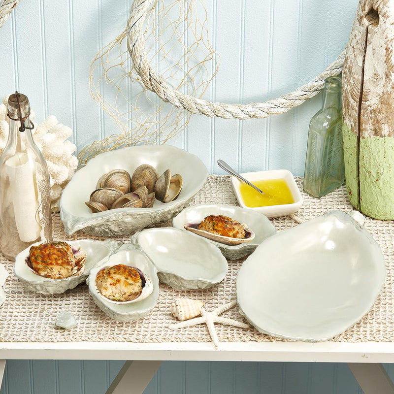 Three white ceramic serving dishes set: two shallow bowls and one large oval platter.