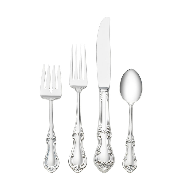 Sterling silver place setting flatware set with ornate forks, knife, and spoon