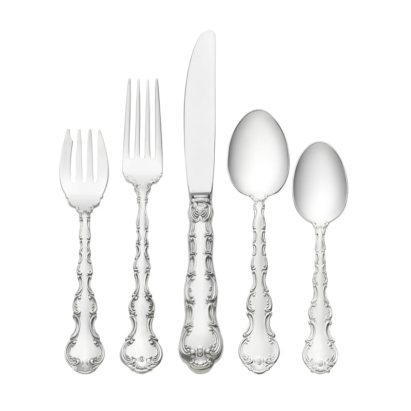 Sterling silver flatware set with ornate handles, forks, knife, and spoons