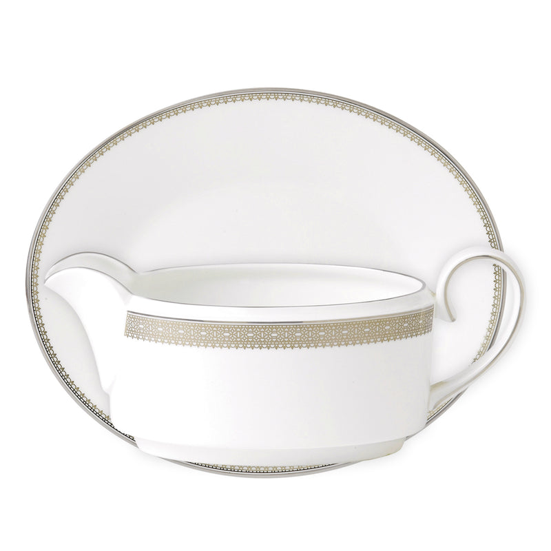 Porcelain gravy boat with gold lace-pattern trim and matching handle