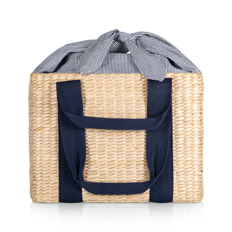 Woven straw picnic basket with navy fabric carry handles and front pocket, striped bow