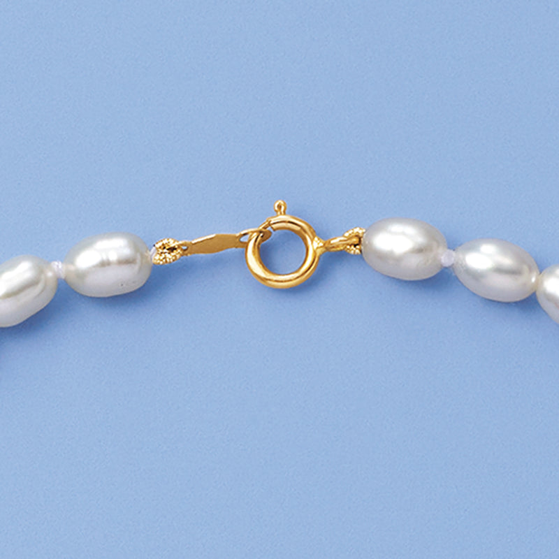 Cultured pearl necklace detail: white pearls and 14kt yellow gold ring clasp