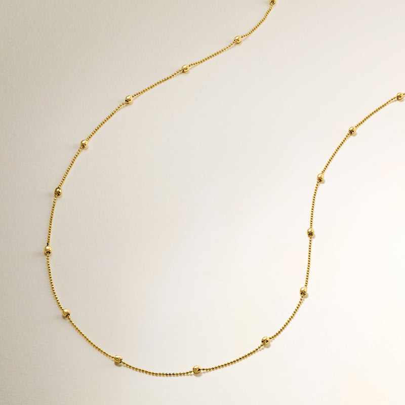 14kt yellow gold bead station necklace with evenly spaced small round beads