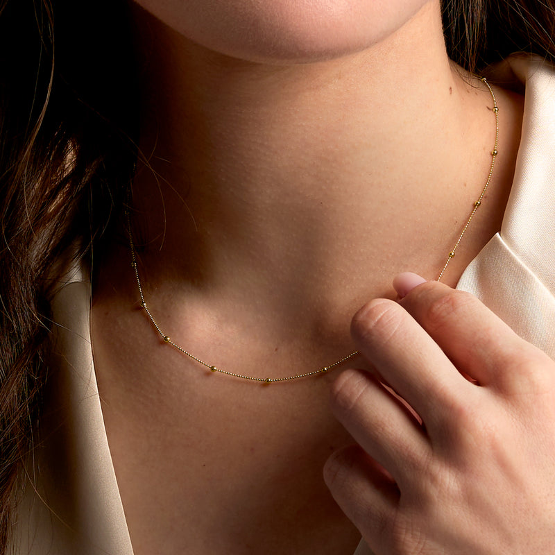 14kt yellow gold bead station necklace worn on collarbone with fine round bead chain