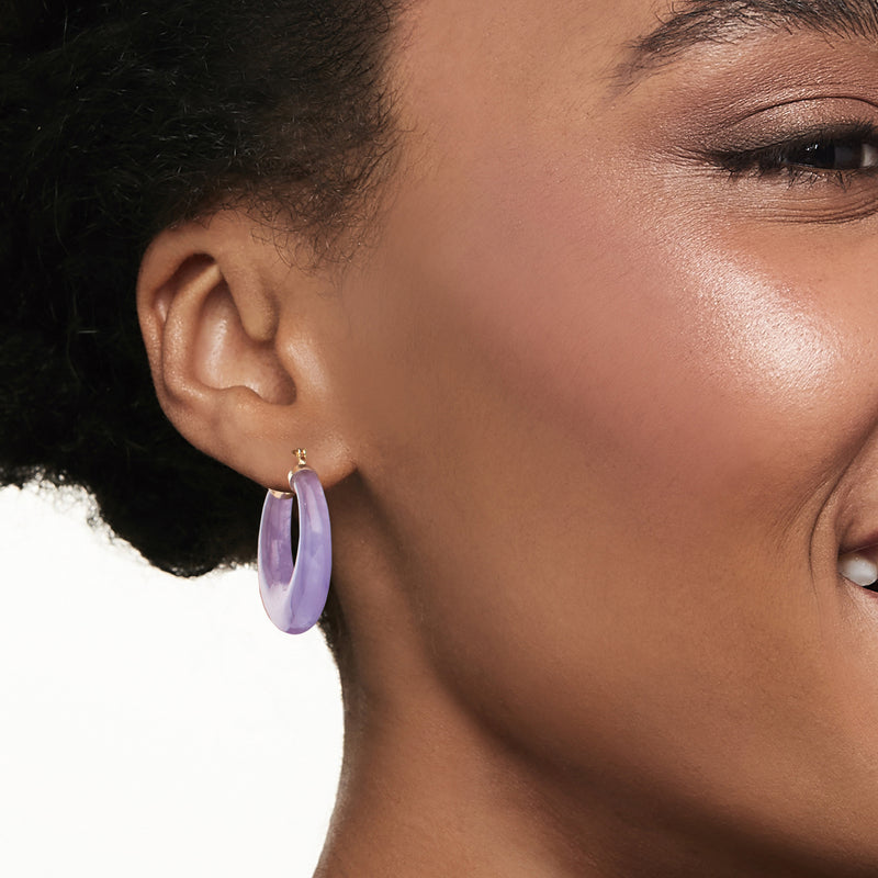 Lavender oval hoop earring in 14k yellow gold on model's ear, close-up