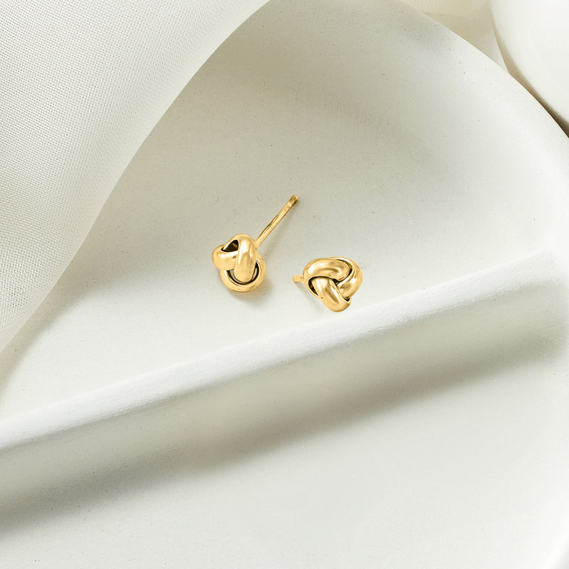Yellow gold love knot stud earrings with visible post and backing