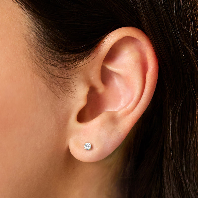 Round diamond stud earring in 14kt yellow gold, worn on ear