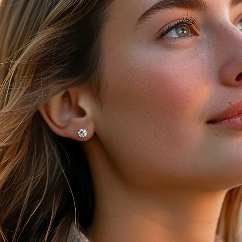 Round diamond stud earrings in 14kt yellow gold on a model, close-up