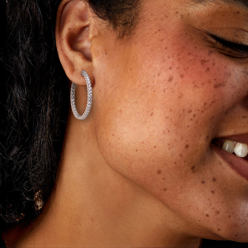 Sterling silver CZ hoop earrings with clear stones on model, oval inside-out sparkle hoops