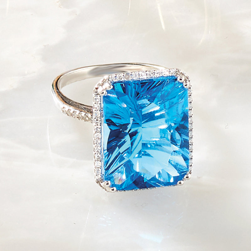 Cushion blue topaz engagement ring with diamond halo and white gold band