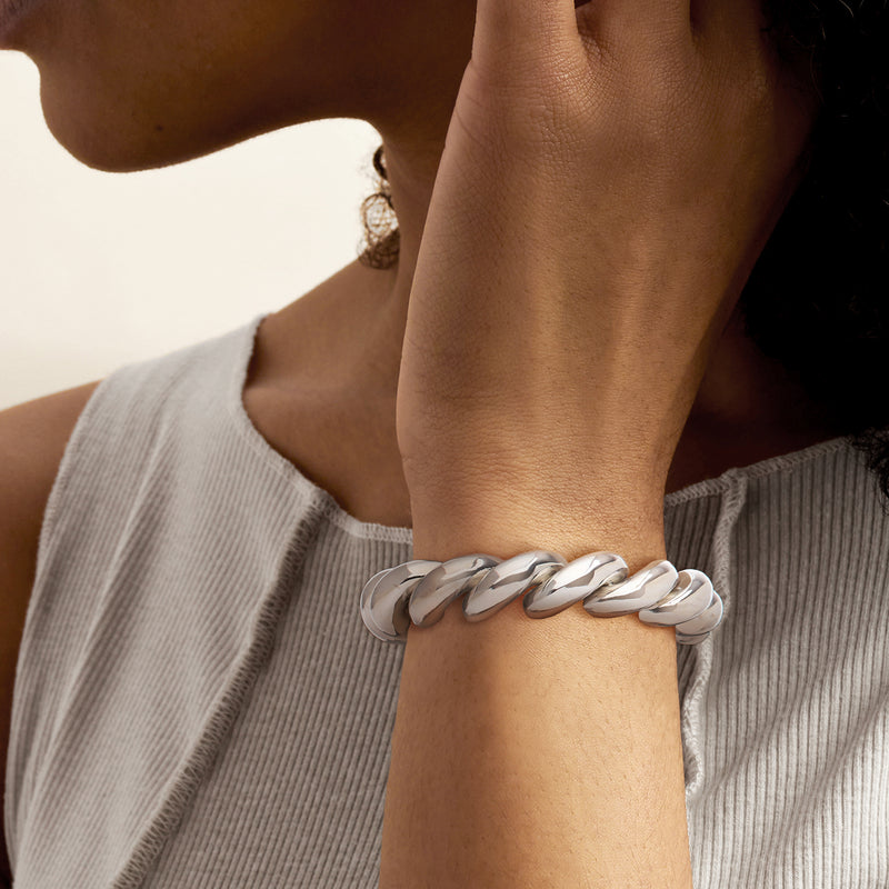 Sterling silver bracelet worn on wrist; curb links with rectangular clasp