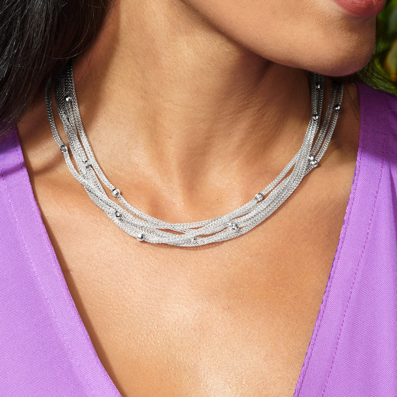 Silver multi-strand mesh necklace worn at the collar with round clasp-like links