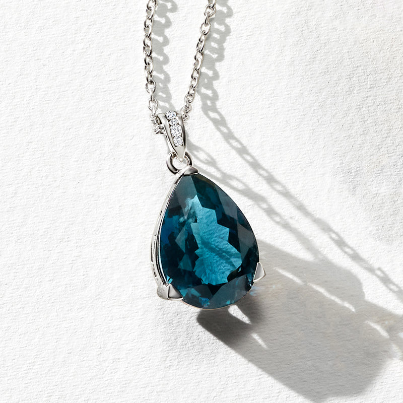 Sterling silver teardrop blue topaz pendant on chain with diamond-set bezel