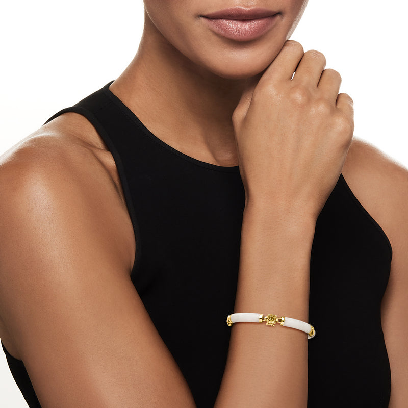 White jade and gold bracelet worn on wrist with small gemstone accents