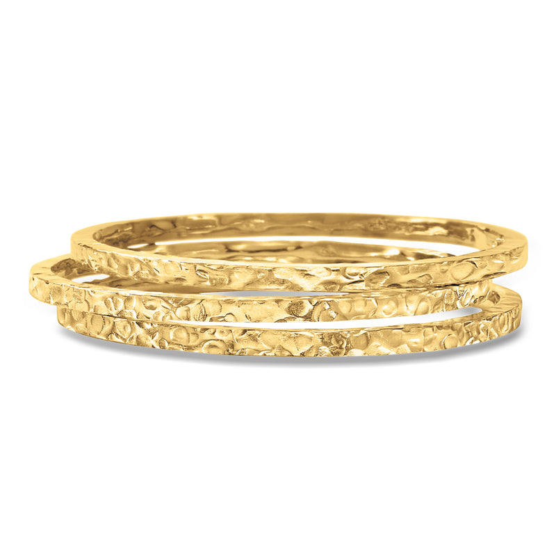 Set of three hammered gold bangle bracelets with textured finish