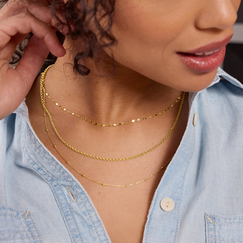 Layered 14kt yellow gold rolo-link necklaces with small oval links and chain closures