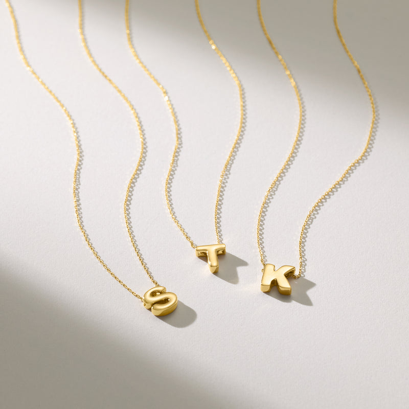Yellow gold mini initial necklaces with small letter pendants on fine chains
