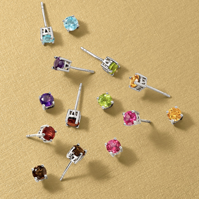 Assorted round gemstone stud earrings in sterling silver, shown laid out