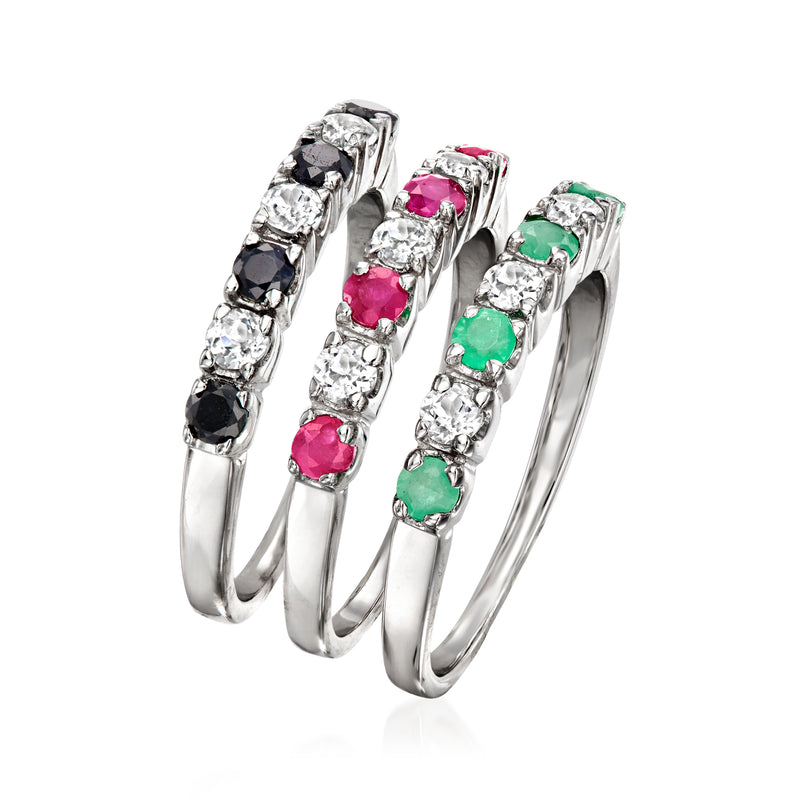 Three stackable sterling silver rings with side-set black, clear, pink, and green stones