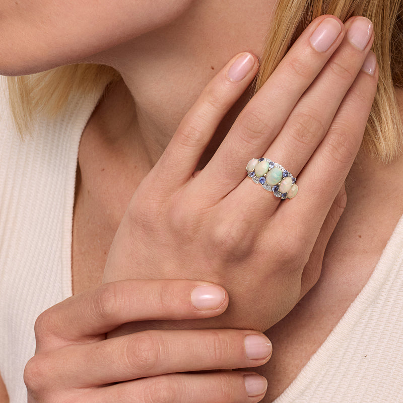Opal-like oval ring in 14kt yellow gold with purple stones and diamond band, on hand