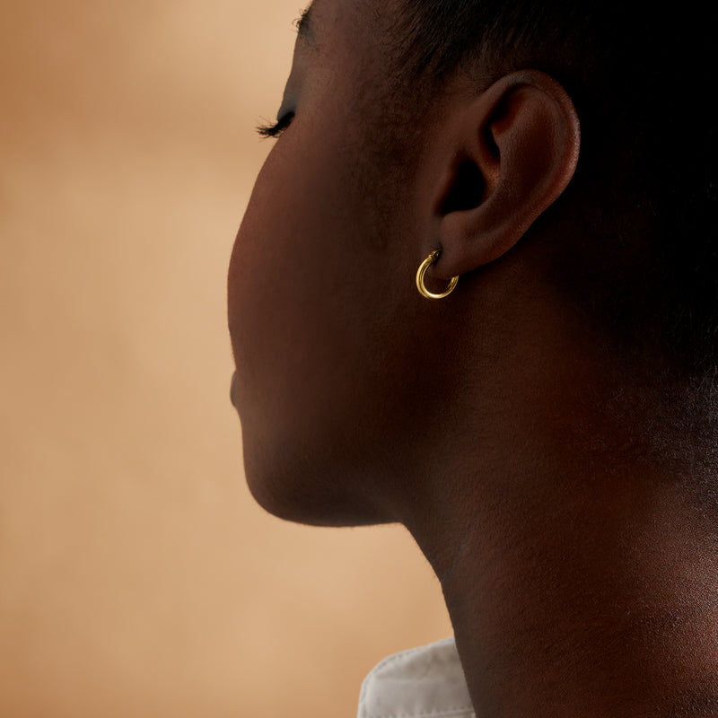 Small polished 14kt yellow gold hoop earring on side profile