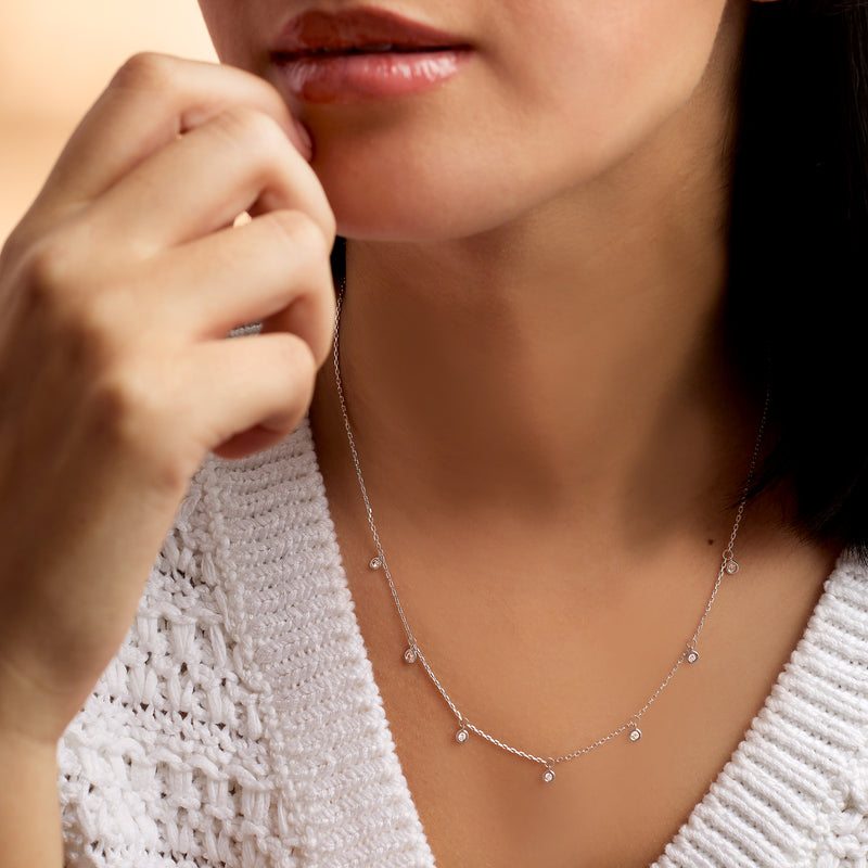 Sterling silver diamond drop station necklace on a model’s neckline, cable chain
