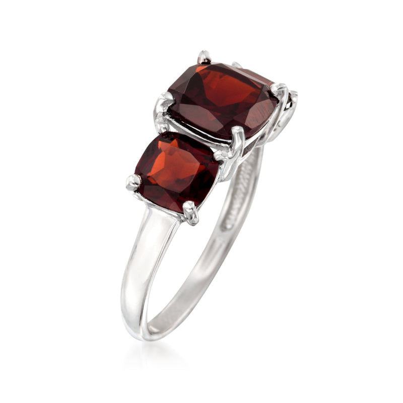 Sterling silver garnet three-stone ring with central dark red stone and two oval side stones