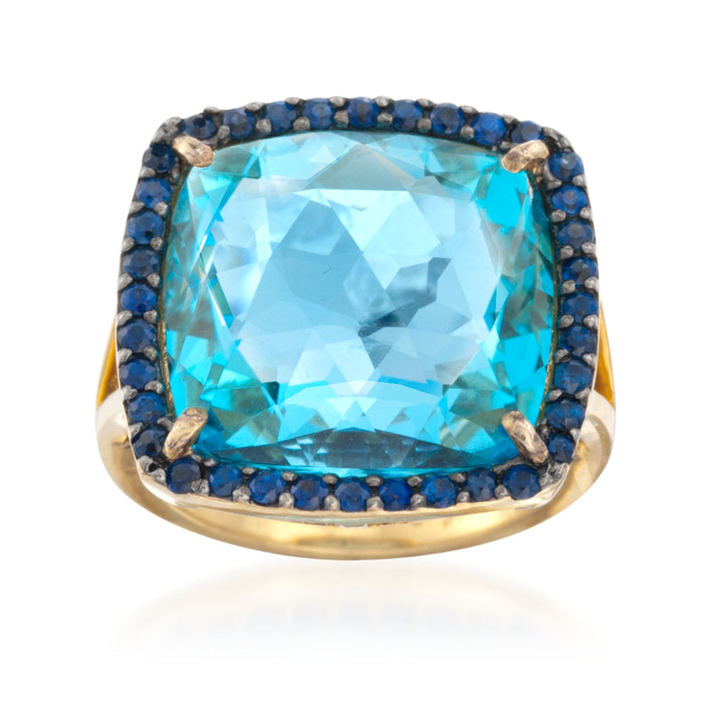 Gold-tone ring with large blue topaz-style gemstone and dark blue sapphire halo