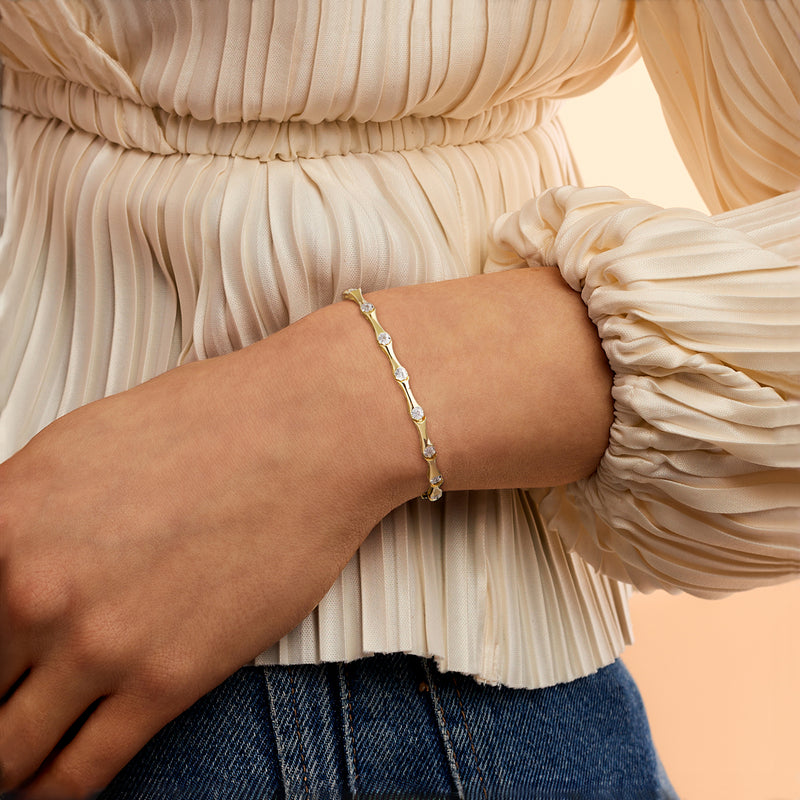 Gold diamond station bracelet worn on wrist with small round stones