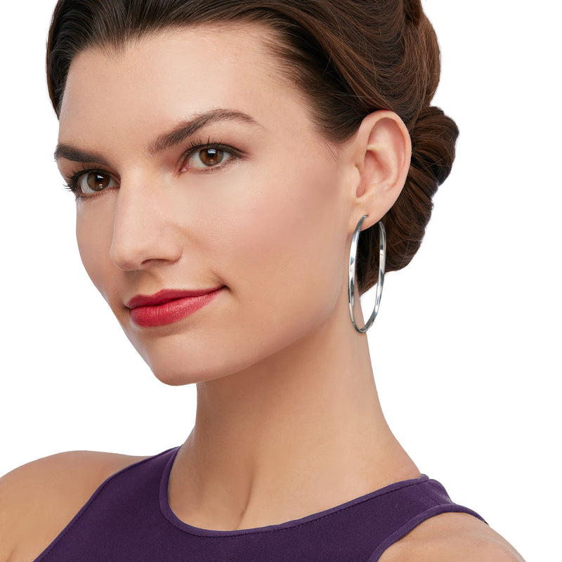 Sterling silver twisted oval hoop earrings on model, close-up