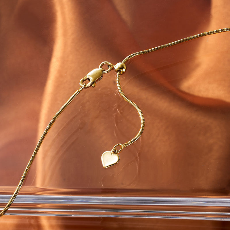 Gold-tone adjustable snake-chain necklace with small heart charm and clasp