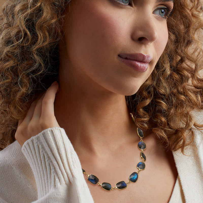 Labradorite necklace worn by model, oval blue-gray stones on gold-tone chain