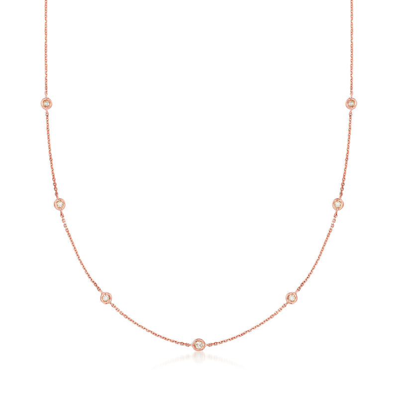 14kt rose gold diamond station necklace with small round stones along curved chain