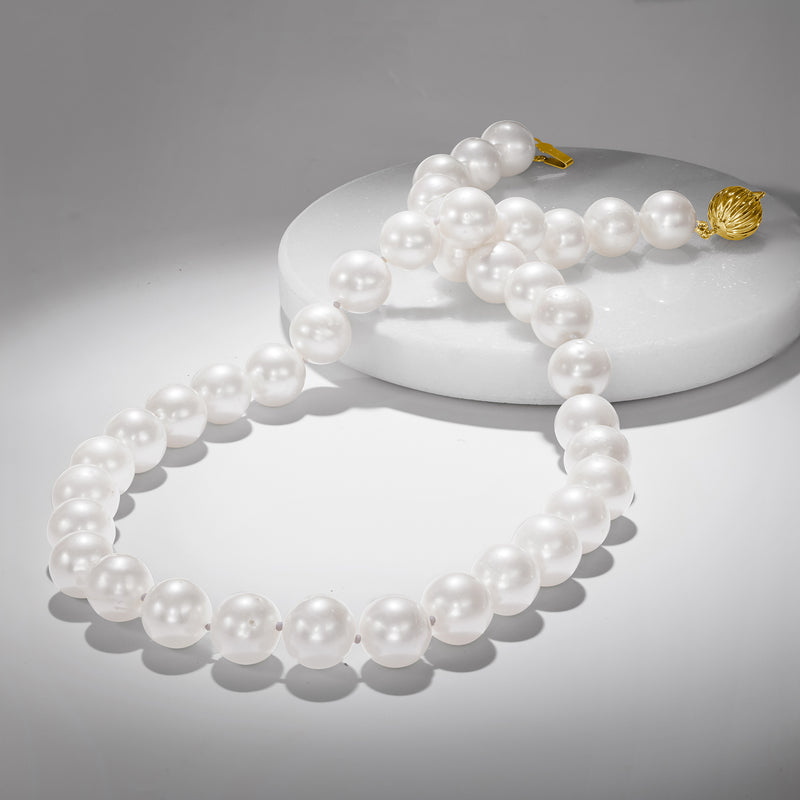 Cultured pearl necklace with knotted strand of white pearls and yellow gold clasp