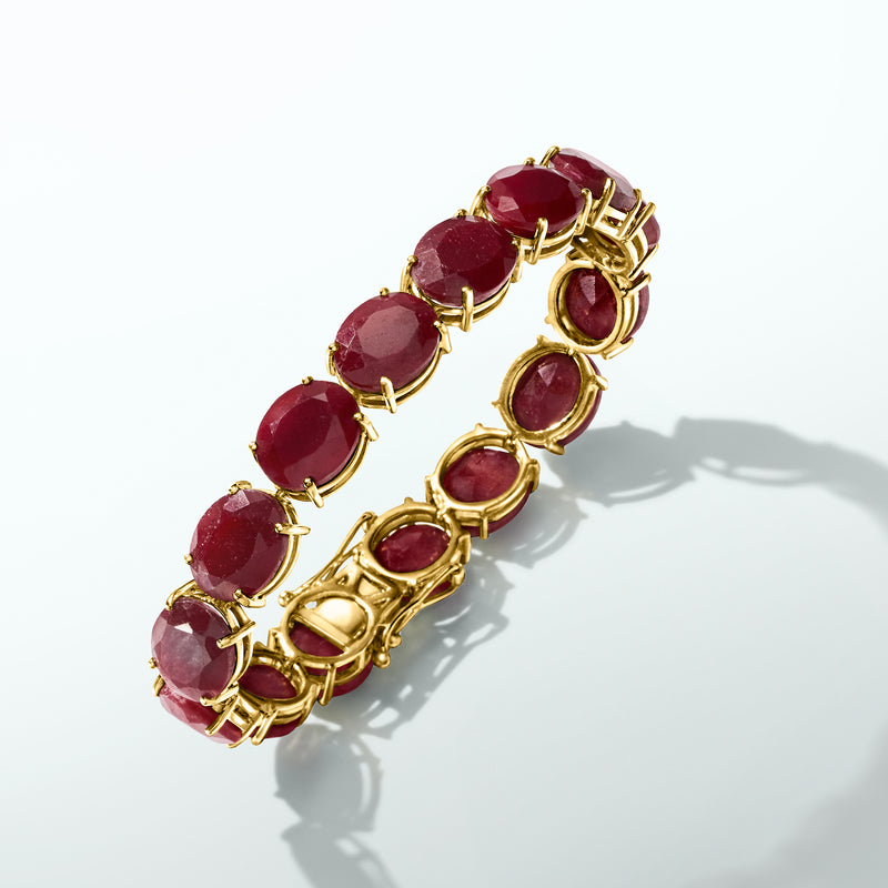 Gold-tone oval gemstone bracelet with maroon red stones in prong settings