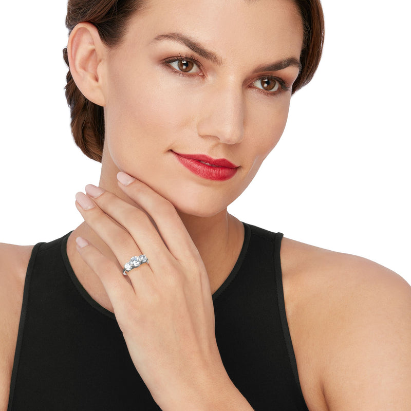 Three-stone CZ ring in sterling silver on hand, round center with two side stones